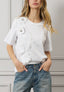 T-shirt con rouches e fiori